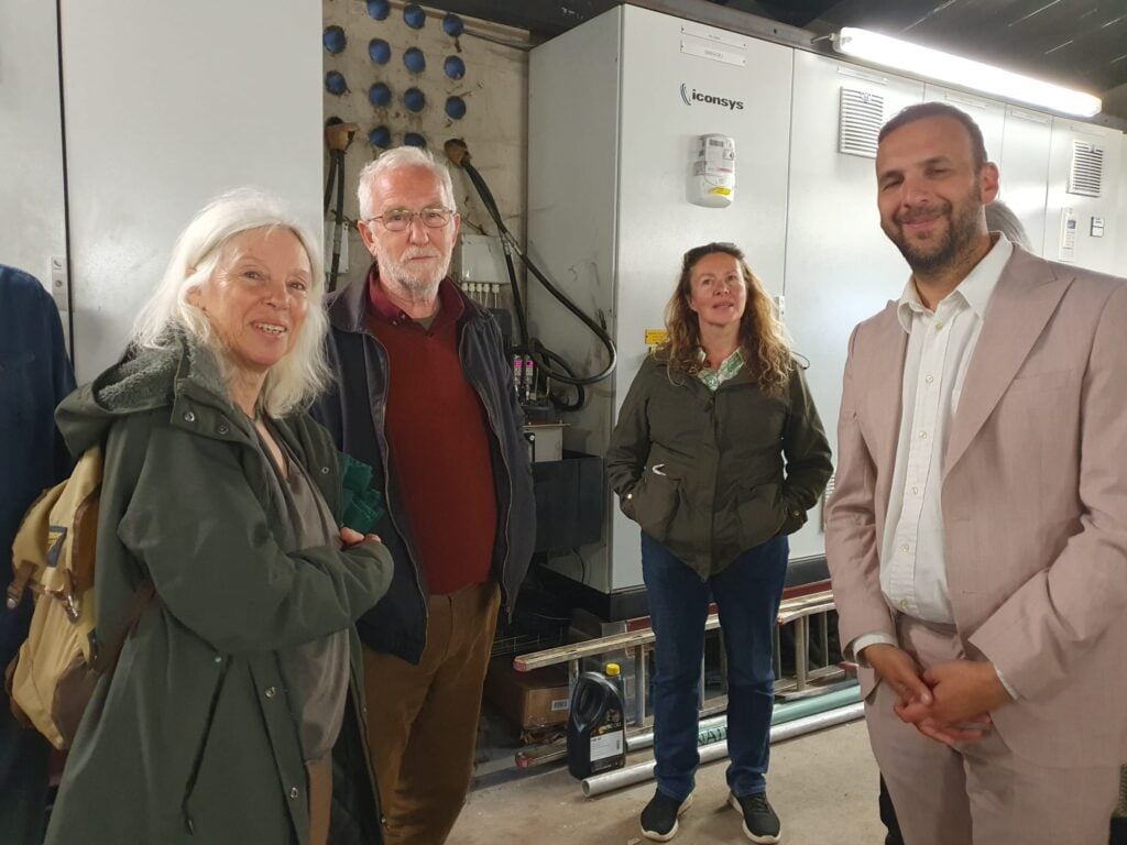 Cllr Jacqi Hodgson, Ian Bright director of TRESOC, Cllr Georgina Allen, and Zack Polanski stand near the turbines at Totnes Weir